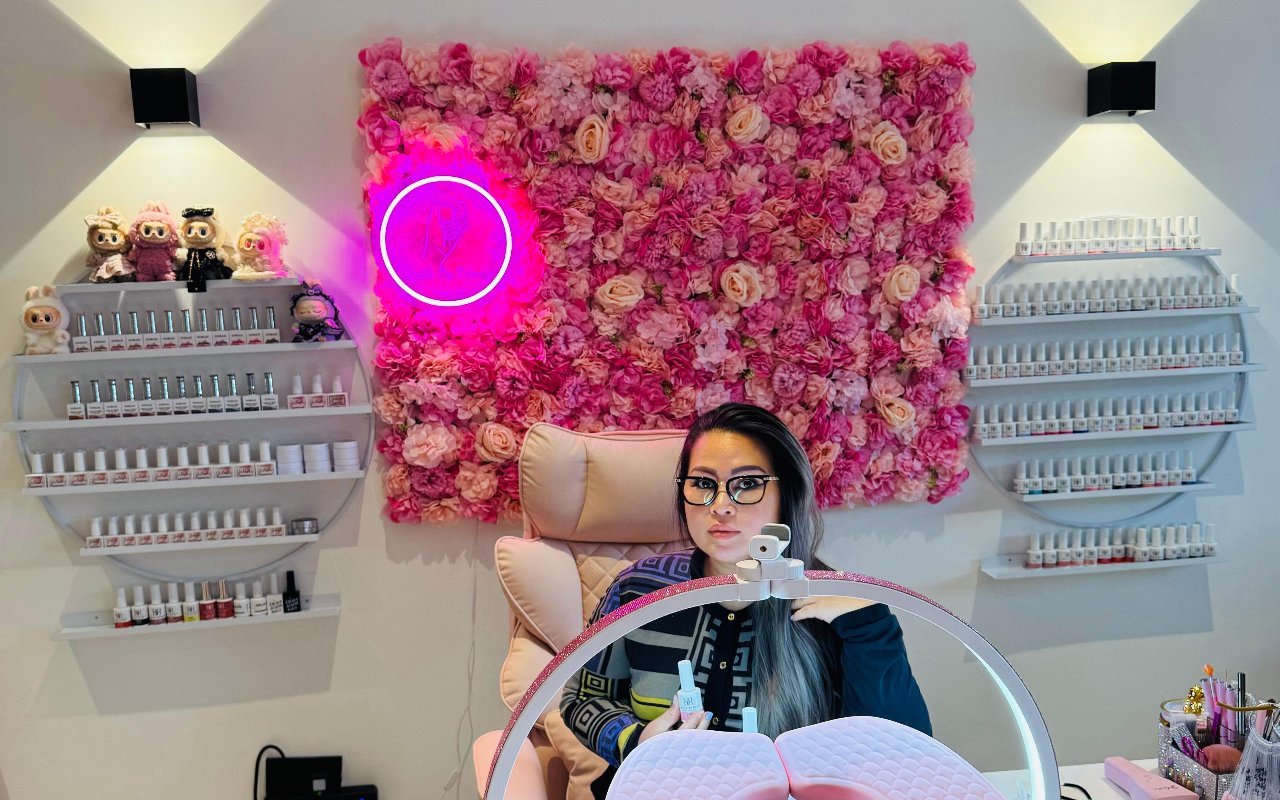 Kim aan haar werktafel voor de bloemenwand
