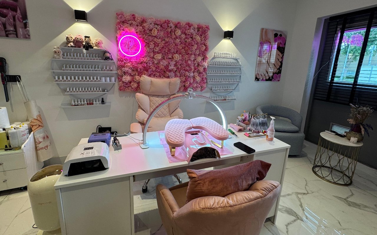 De werktafel met lamp en de roze stoelen voor de bloemenwand