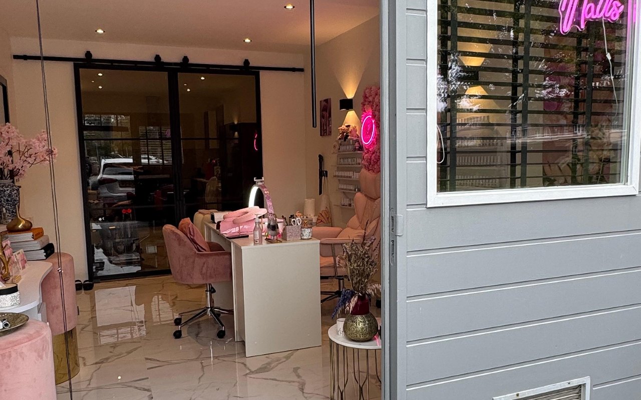 Doorkijk door de salon naar de ingang met de roze neon
