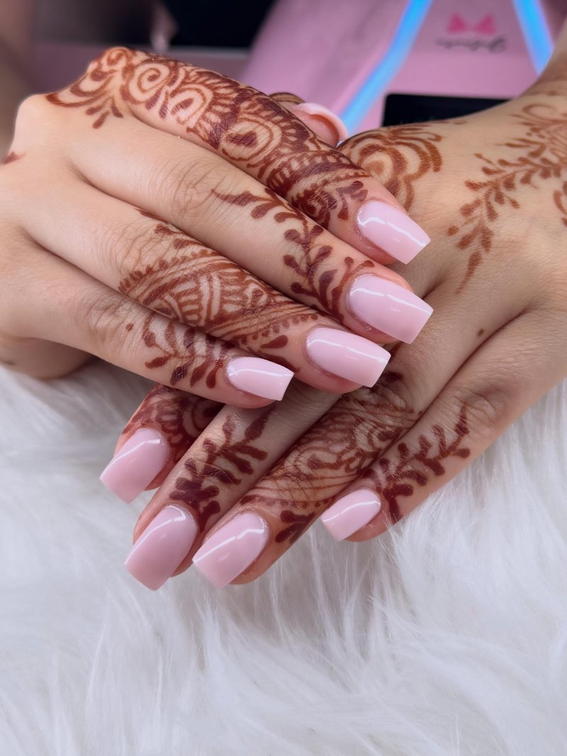 Zachtroze nagels op handen met henna